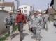 Governor Tim Pawlenty on a walking tour of Vitina, Kosovo with CPT Jeff Blowers, from St. Cloud, Min...